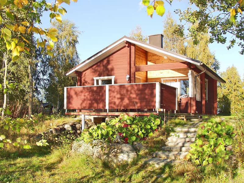 Punainen puurakennus avarine terasseineen ja kiviportaineen aurinkoisena syyspäivänä